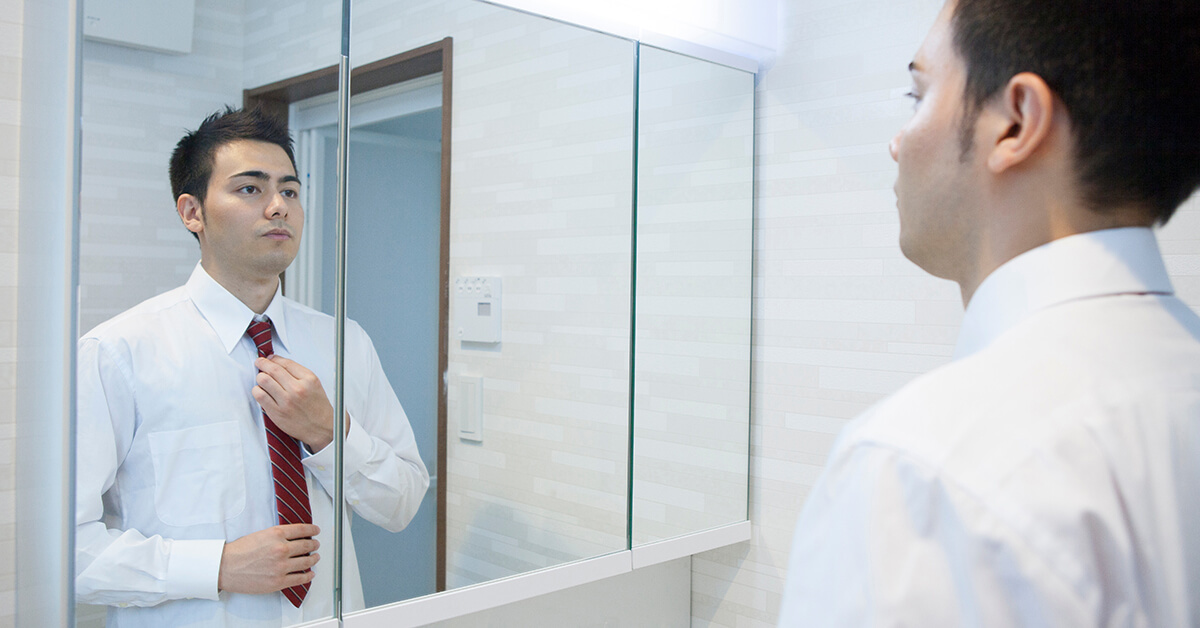 Man Who Is Nervous Tying His Tie In Front Of Mirror