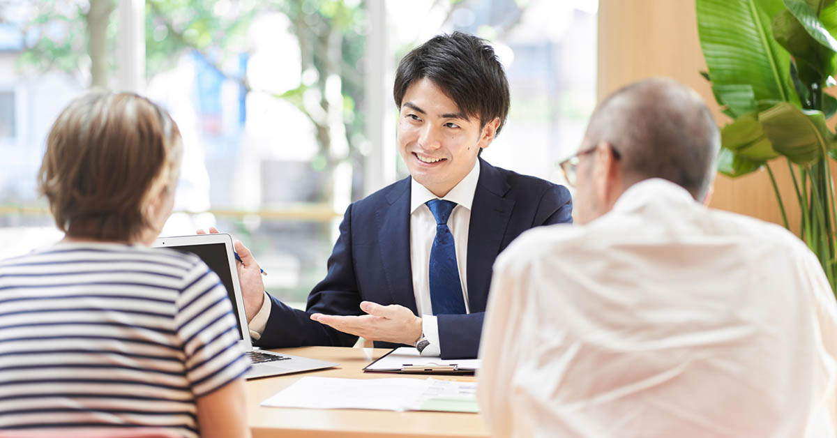顧客に資料の説明をしている営業マン