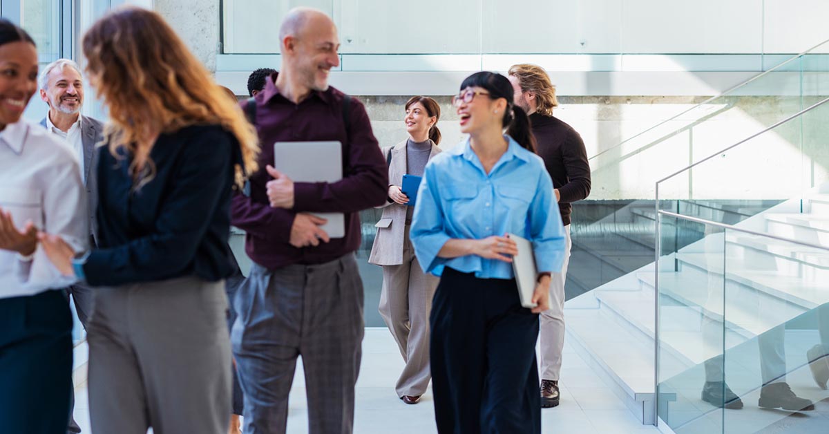 外資系企業で働く多様なビジネスパーソンがオフィス内を歩きながら会話している様子