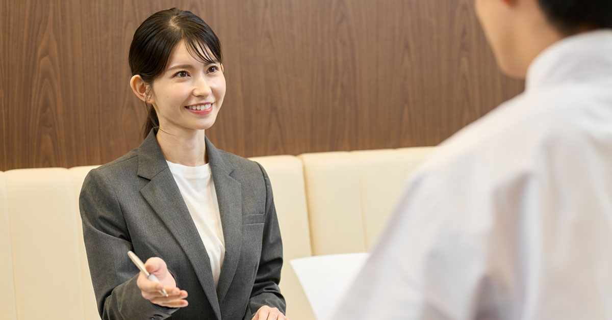 病院で医師とディスカッションする製薬会社の女性PMS担当者