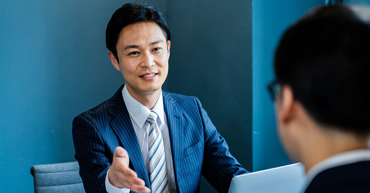 外資系転職でカバーレター添削を受ける男性がコンサルタントと相談する様子