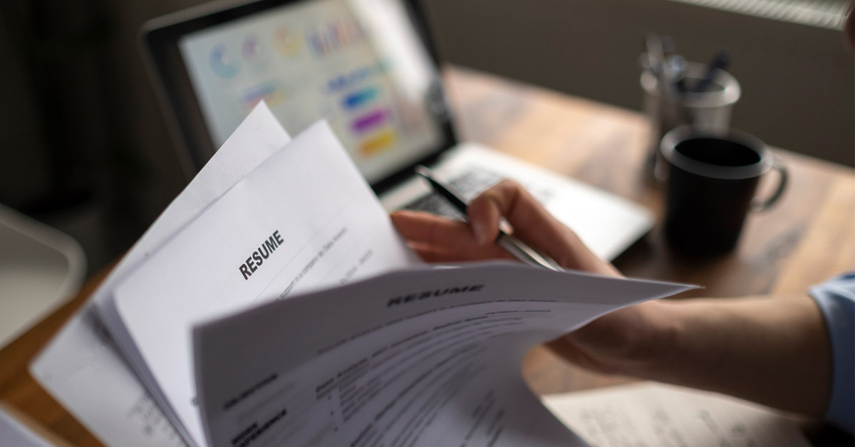 スタートアップ企業の採用担当者が履歴書を確認しながら採用に悩む場面