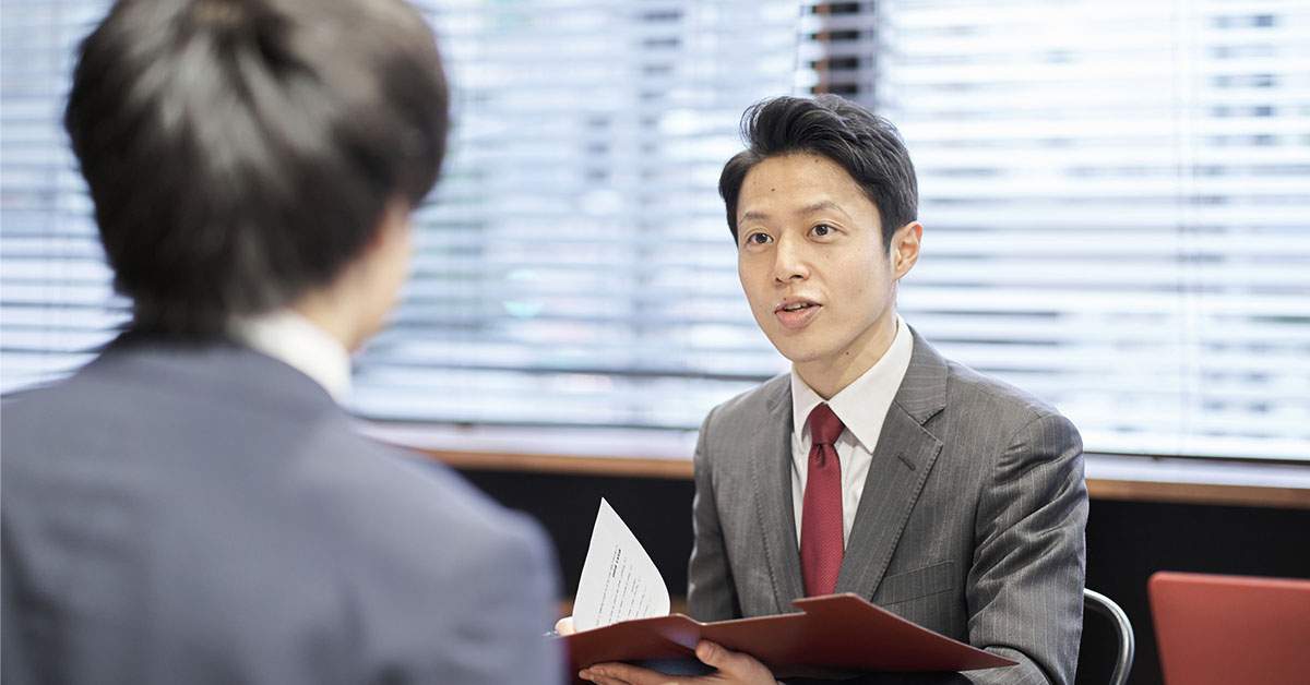 外資系IT営業で事業開発のキャリアを歩む男性が、クライアントと打ち合わせをする様子