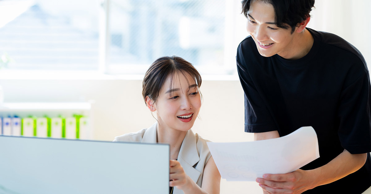 女性のPMとPMOのメンバーである男性がプロジェクトについて話している様子