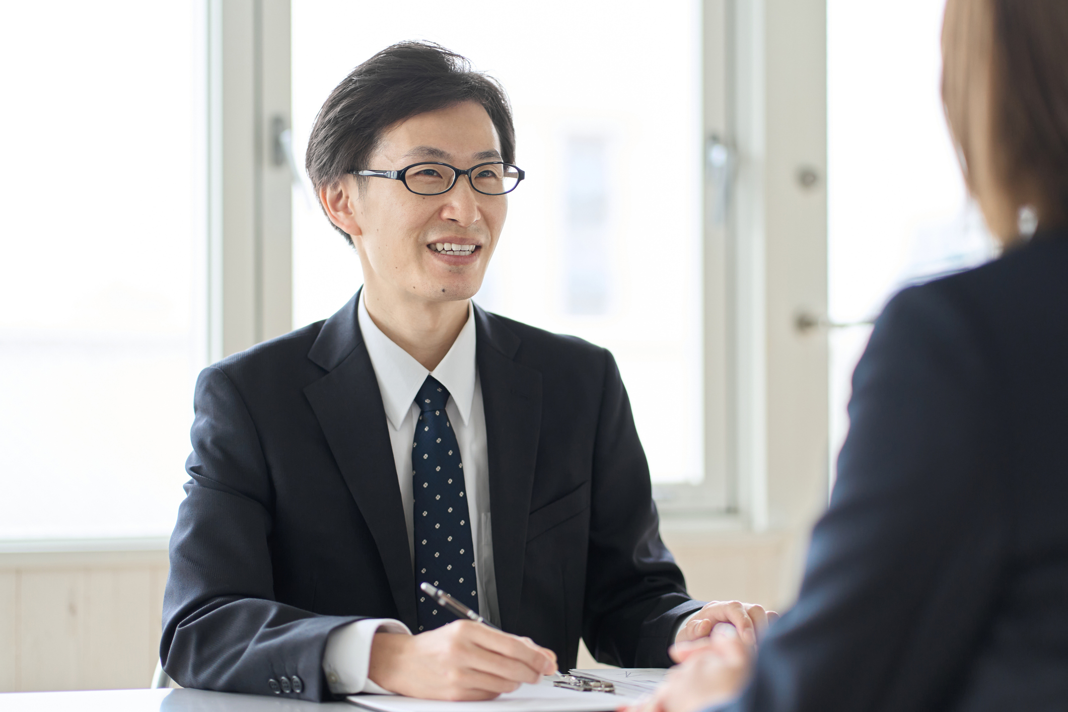 40代の転職面接に臨むビジネスパーソンと面接官のシーン