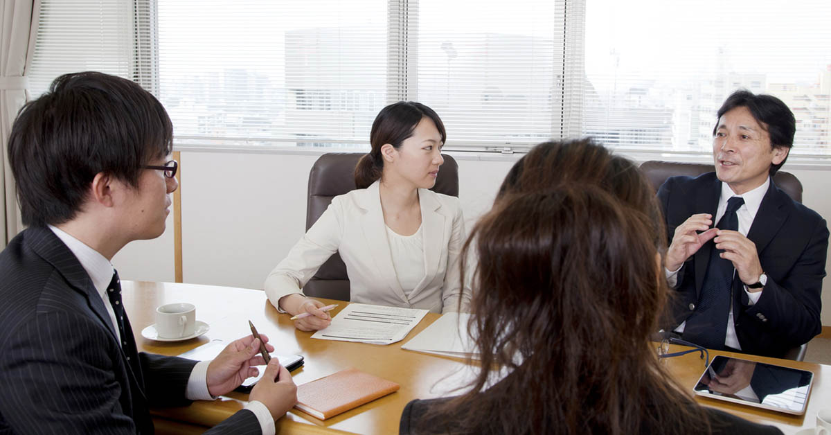 会議室で話し合う法務・コンプライアンス担当者たち