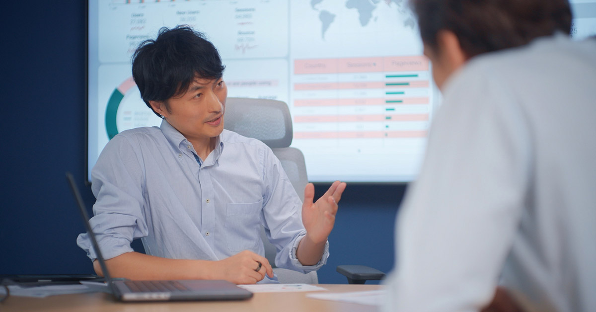 FP&A担当者が会議室でデータをもとに説明している様子