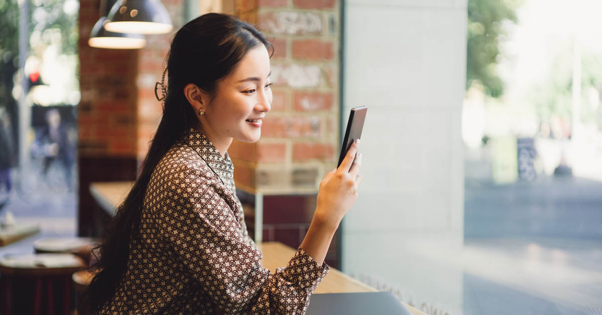 仕事の合間にスマートフォンで求人を見るビジネスウーマン