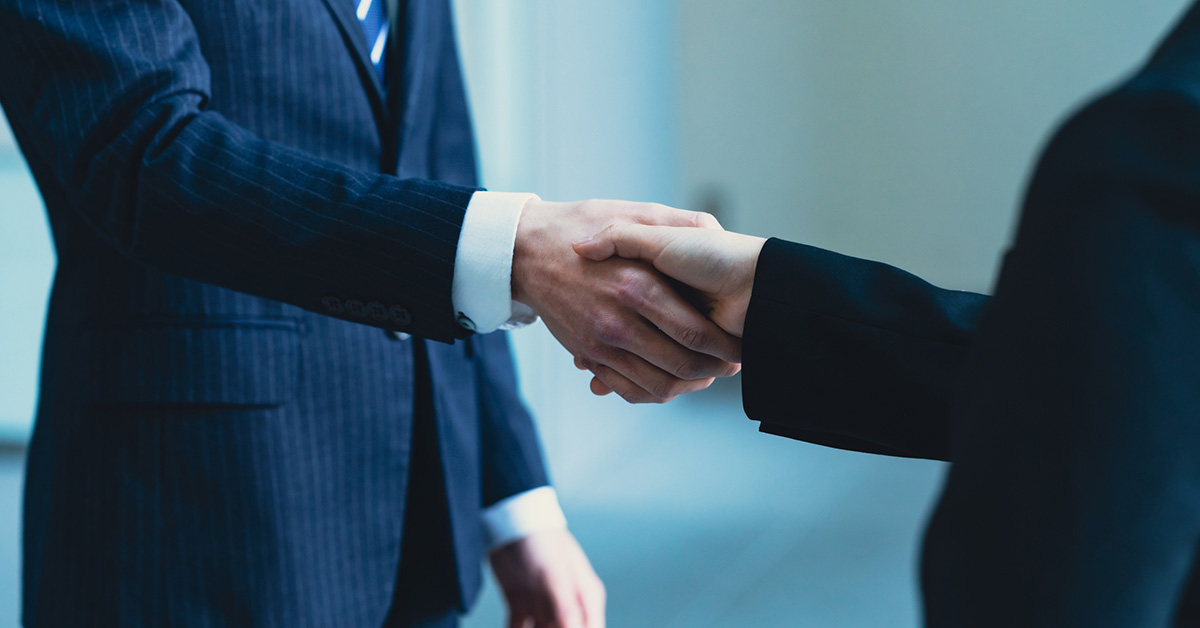 自分の市場価値を知りたい転職者がコンサルタントと握手する場面。転職成功に向けた信頼できるパートナー選びを象徴。