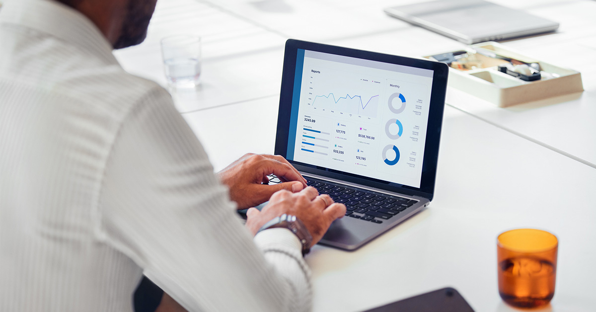 専門性を磨き、自分の市場価値を高めるためにPCを使いデータ分析へ集中するビジネスマンの様子。