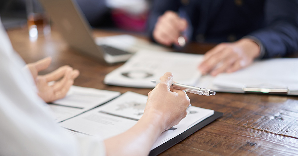 転職希望者がコンサルタントと履歴書テンプレートを確認しアドバイスを受ける様子。