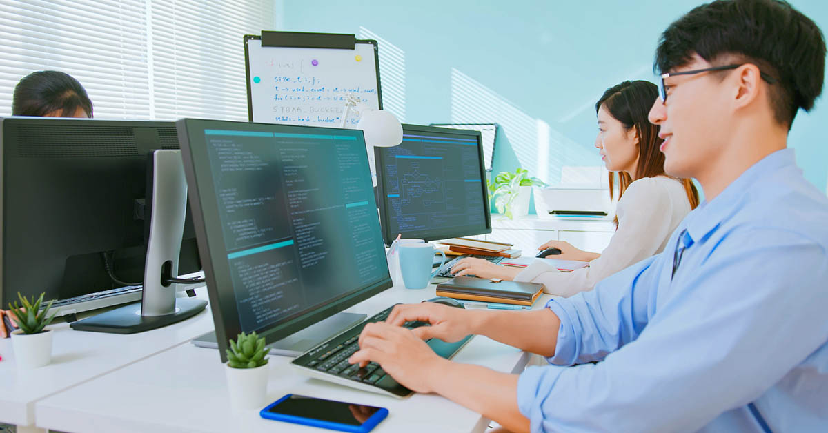 企業のIT部門で働くエンジニアの同僚たちが仕事をしている様子