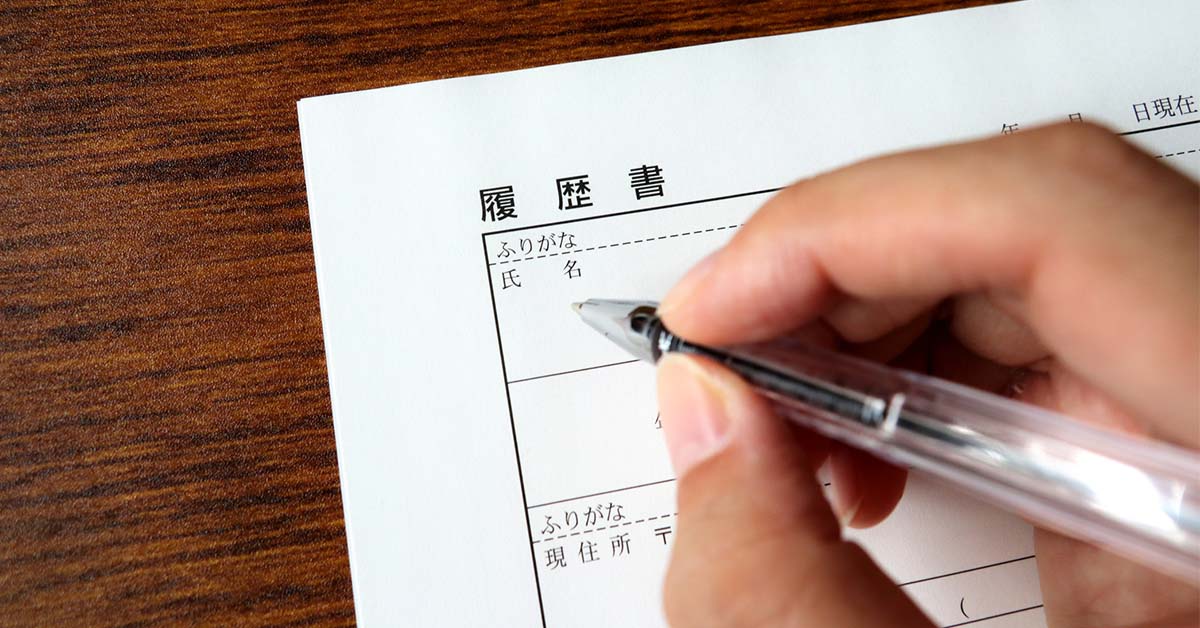 履歴書テンプレートを使い必要項目を丁寧に記入する手元の様子。