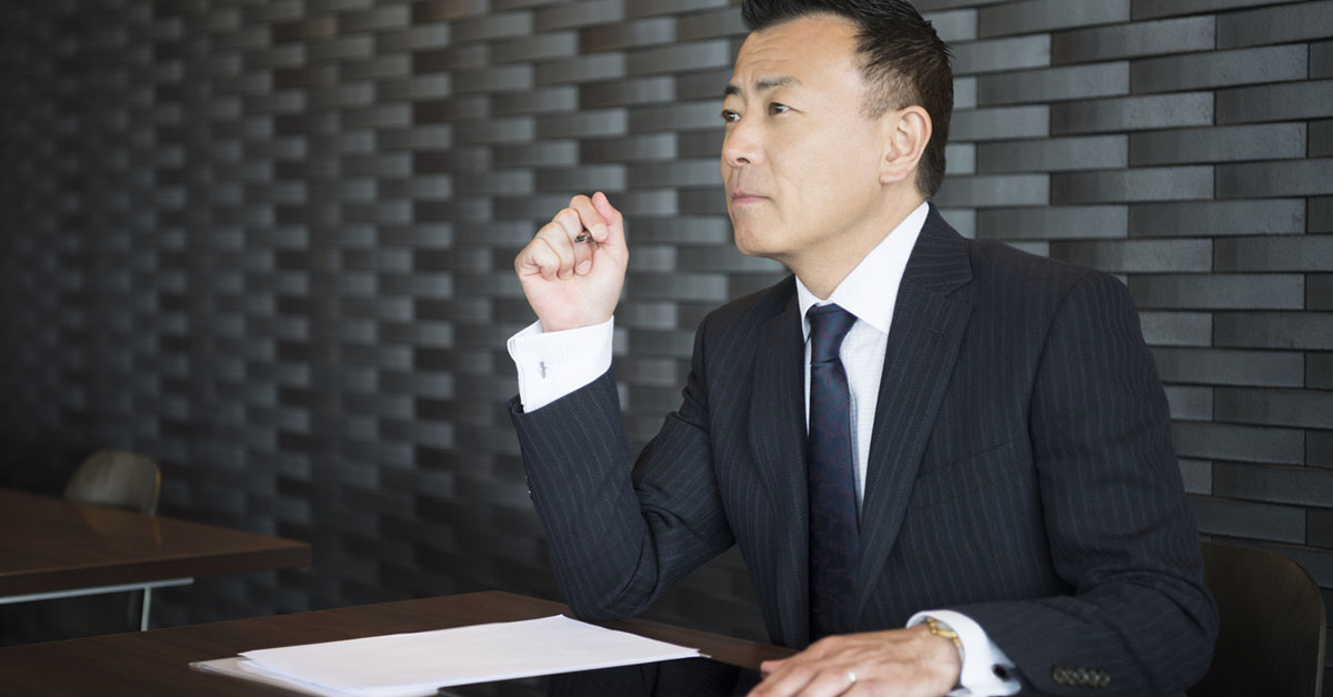 内部統制や内部監査の会議に参加する男性社員が会議室で着席している様子