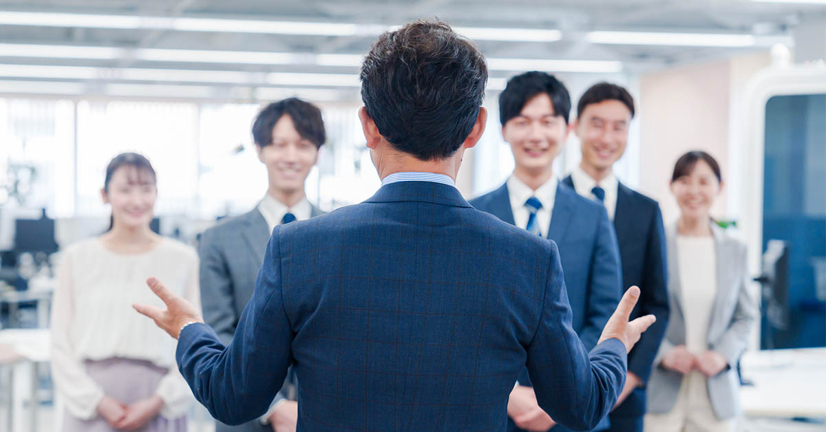 転職後に新しい職場でチームに挨拶する40代管理職男性｜転職成功のスタートシーン