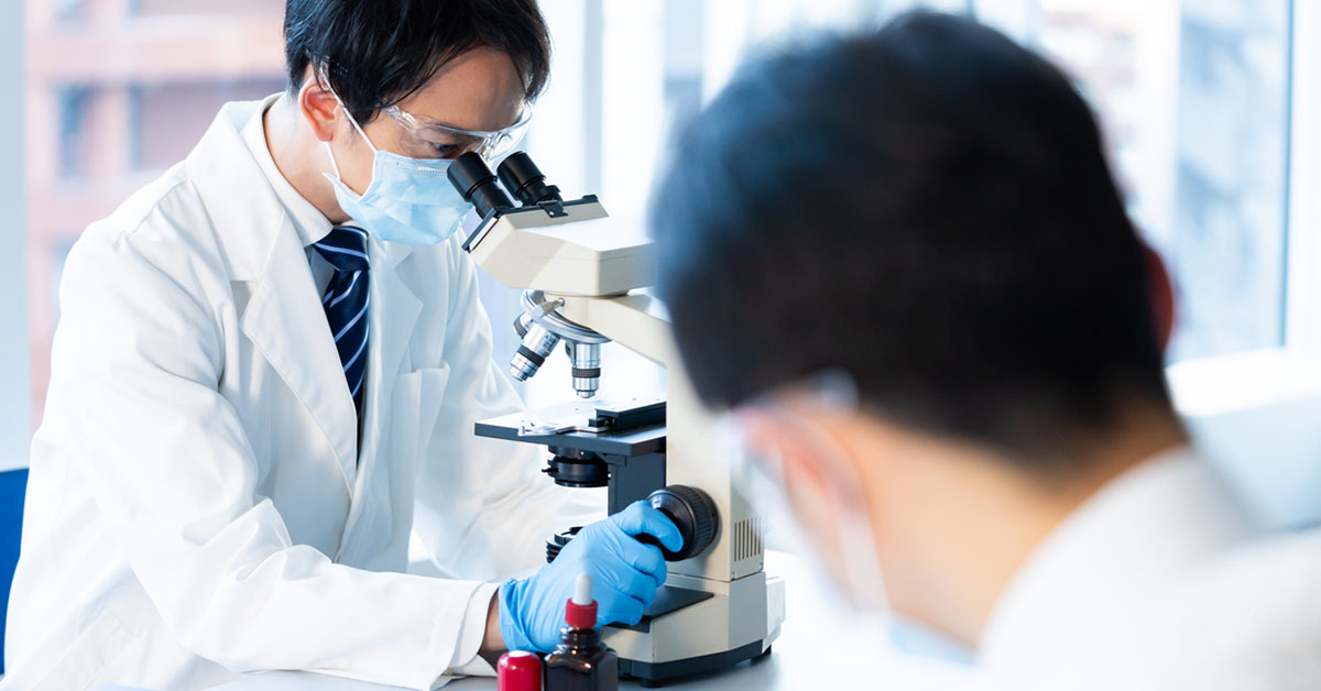 白衣を着て研究に取り組む製薬企業の研究職の日本人男性