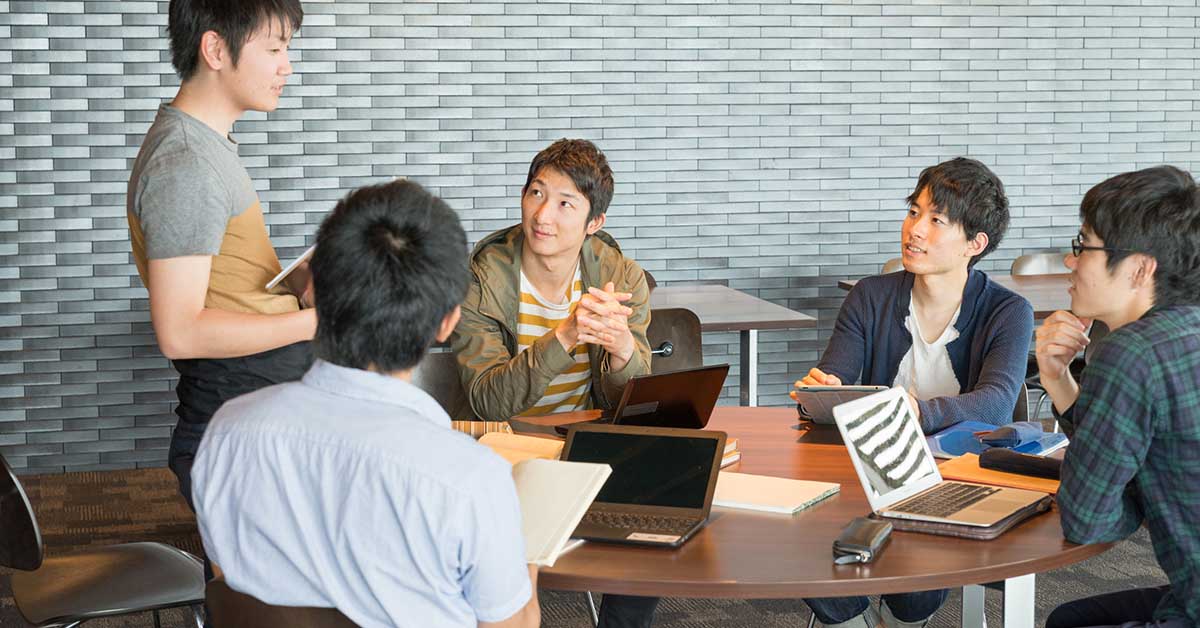 スタートアップ企業のチームミーティングで、積極的に発言する成長意欲のある男性。