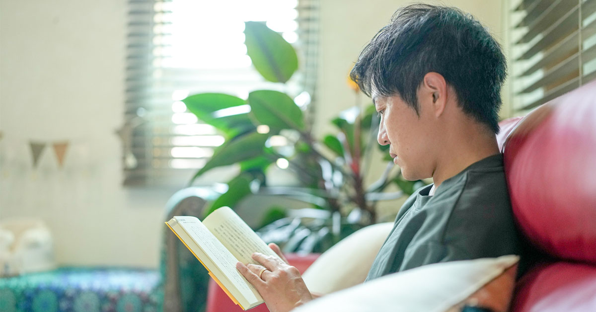 キャリア成長に活かすためソファで資格勉強する40代の男性の図