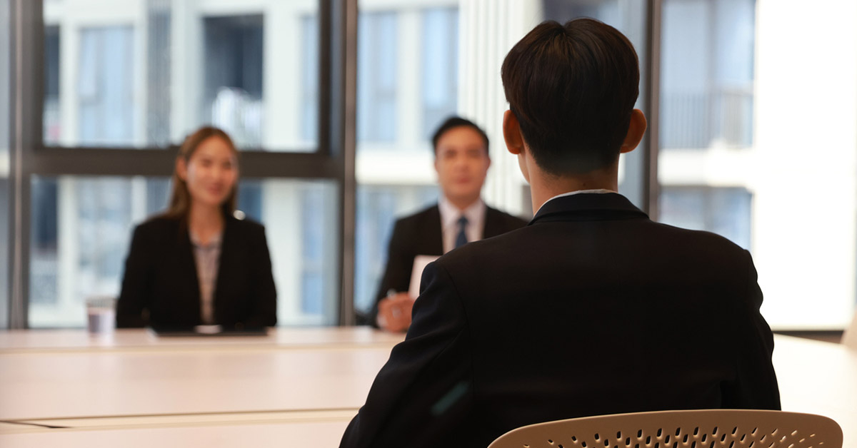 転職面接で面接官と向き合うビジネススーツ姿の男性候補者