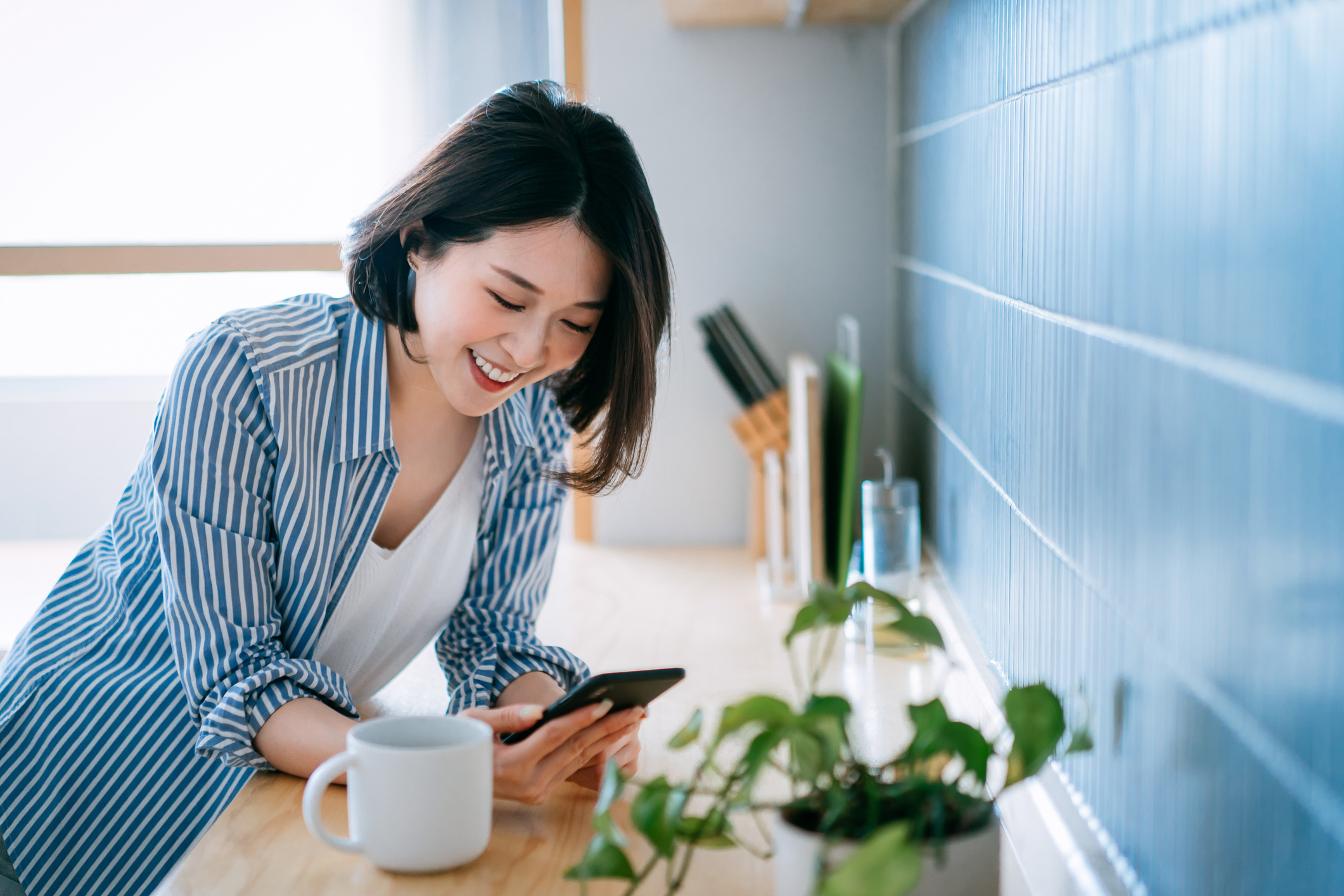 10月入社で夏のボーナスを受け取った女性がスマホを確認している様子