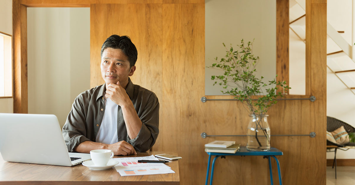 自宅デスクでキャリアの棚卸しを行いながら振り返る男性の様子
