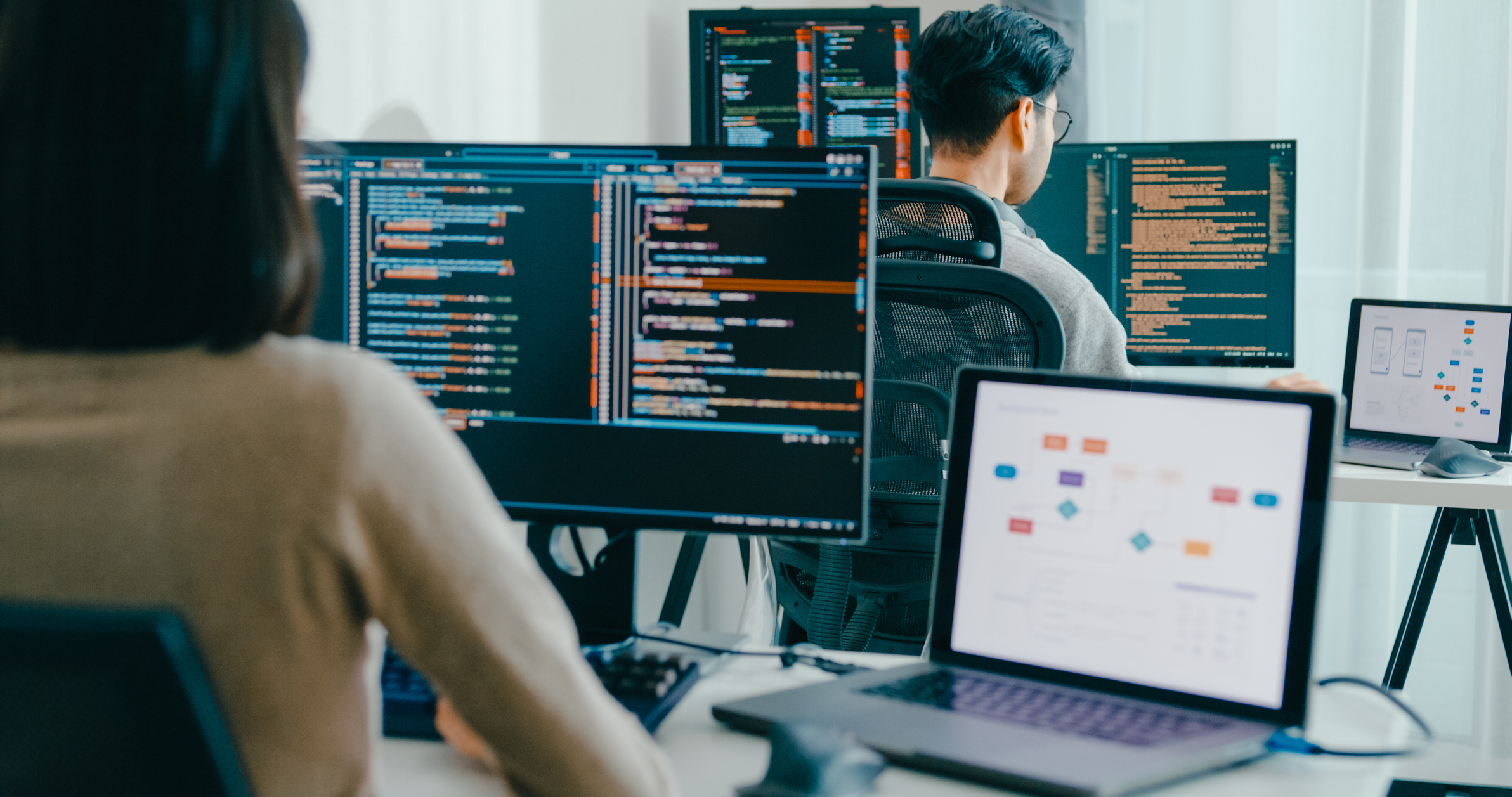 10月入社に適した業界例として、IT業界でパソコン作業をしている人々