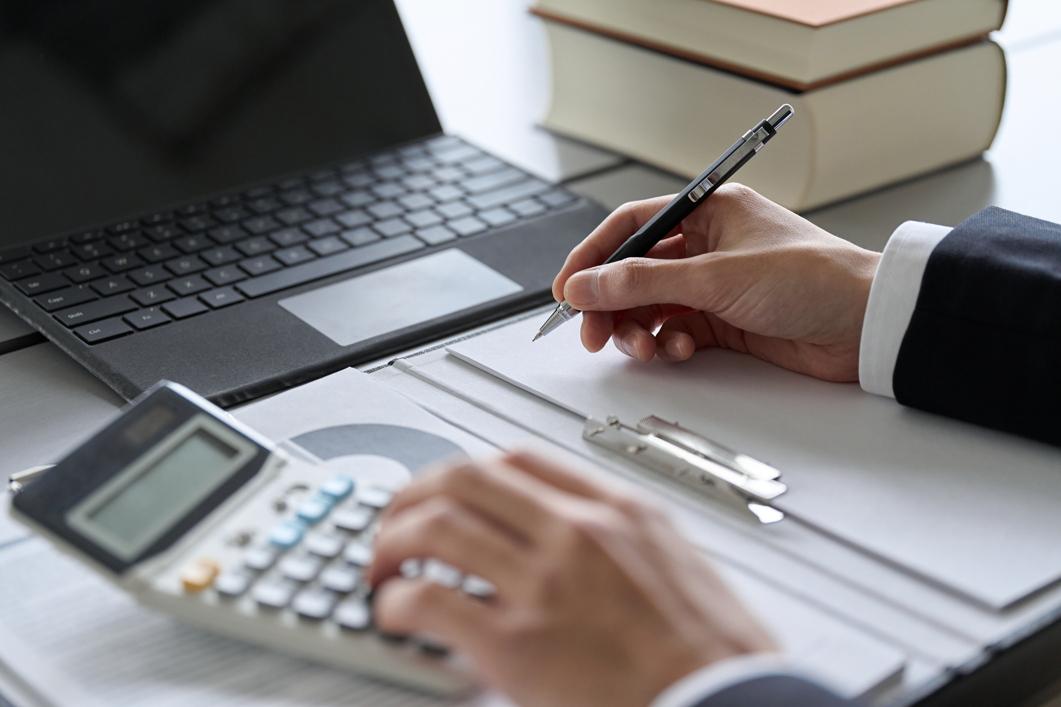 40代の転職で有利な金融系資格取得を目指し、電卓を使って勉強する男性の図