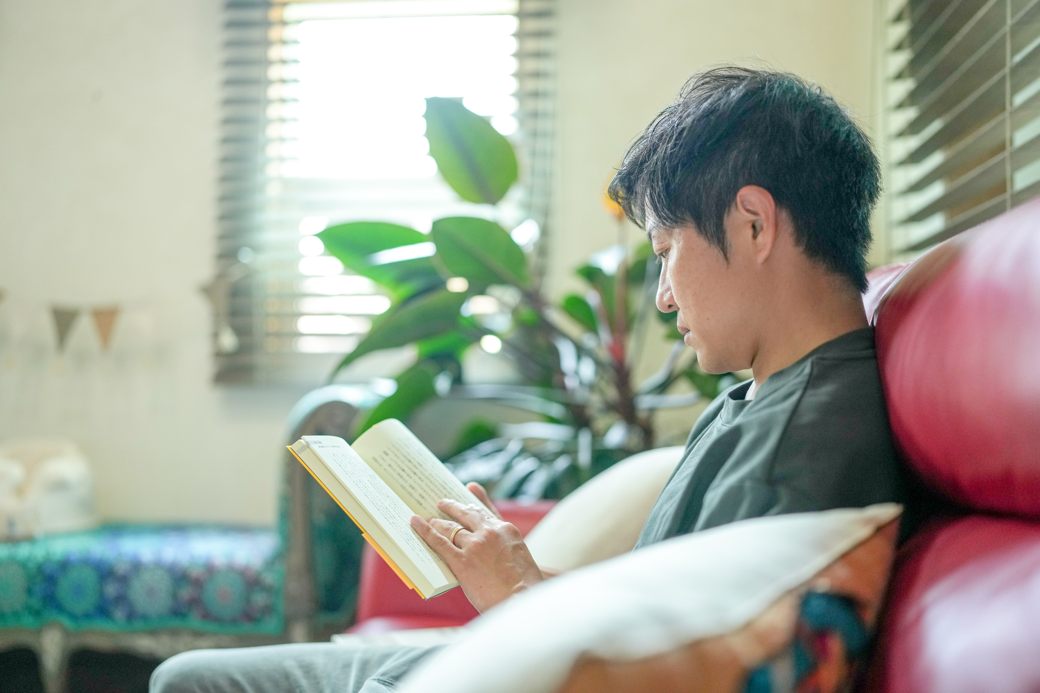 キャリア成長に活かすためソファで資格勉強する40代の男性の図