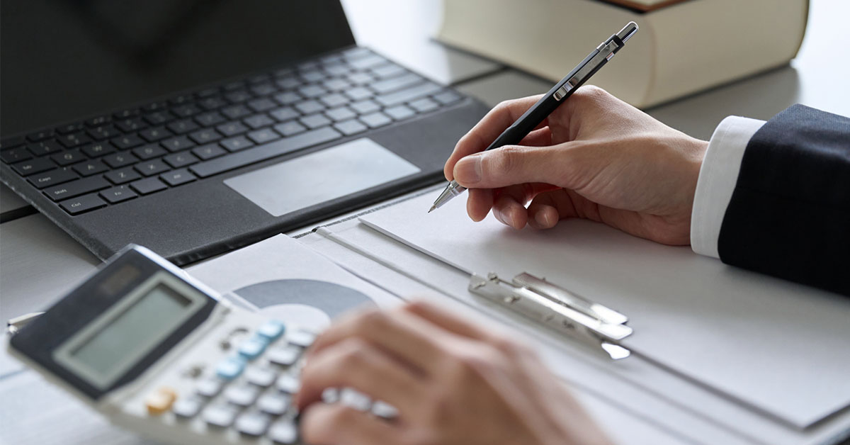 40代の転職で有利な金融系資格取得を目指し、電卓を使って勉強する男性の図