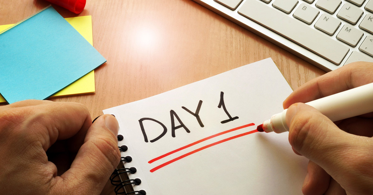 ノートにDay1と書く人の手