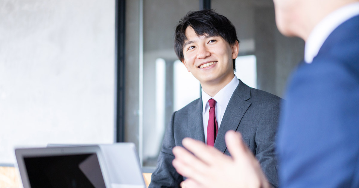 顧客と話をしているIT営業マン