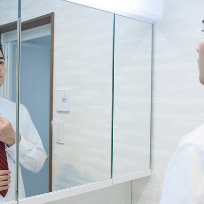 Man Who Is Nervous Tying His Tie In Front Of Mirror